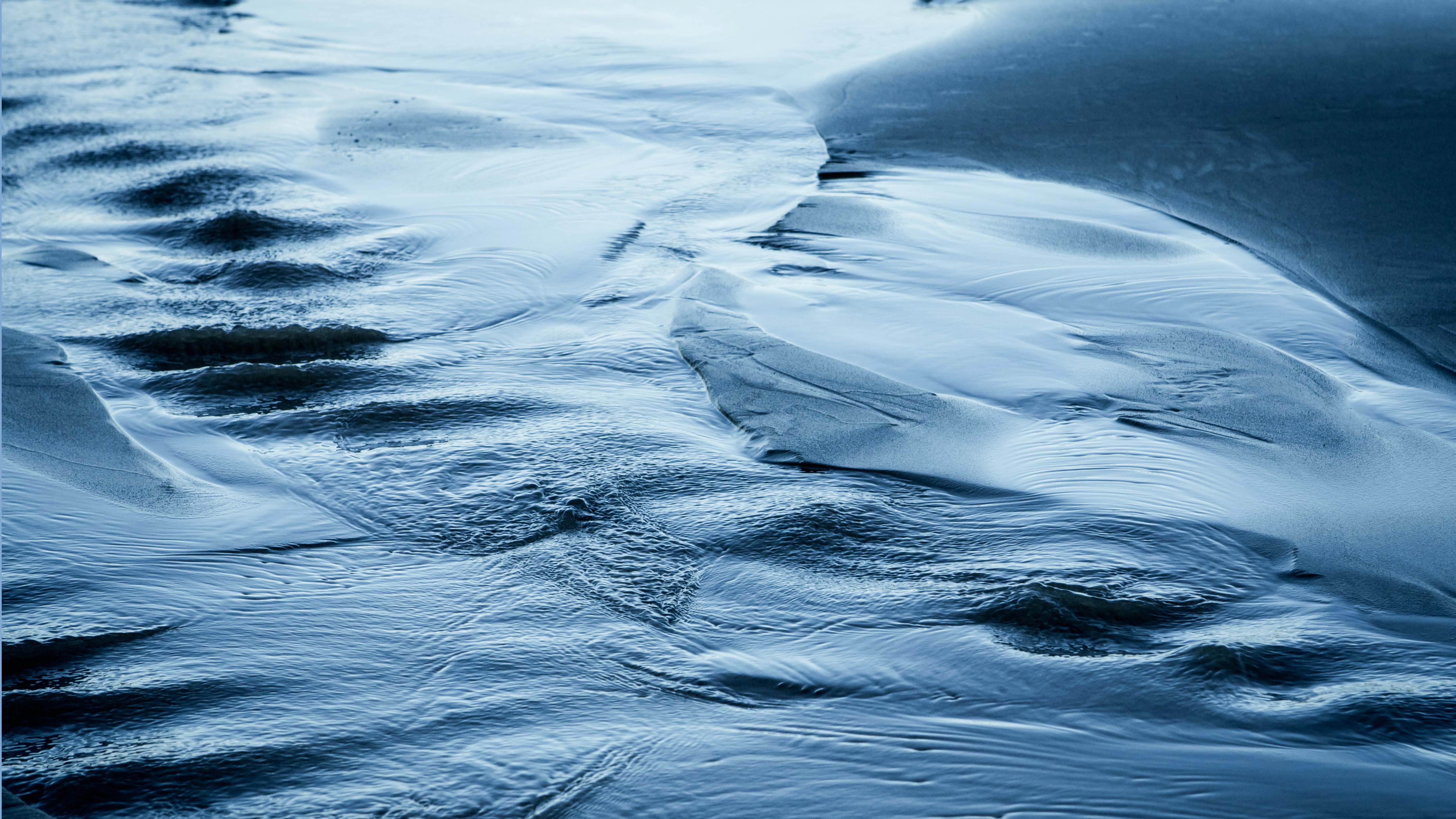photo of water running over sand