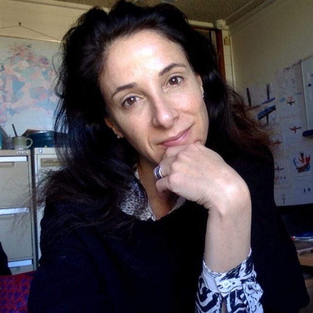image of woman, long brown hair, hand on chin and staring at camera