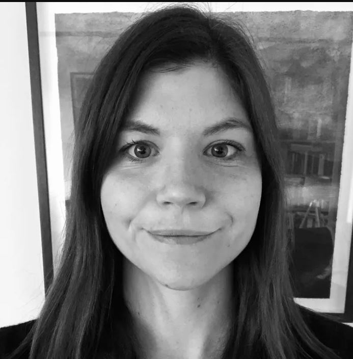 woman smiling at camera, brown hair in black and white image 