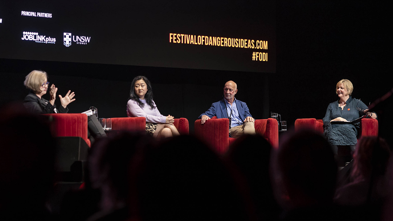 A panel of speakers sitting on stage
