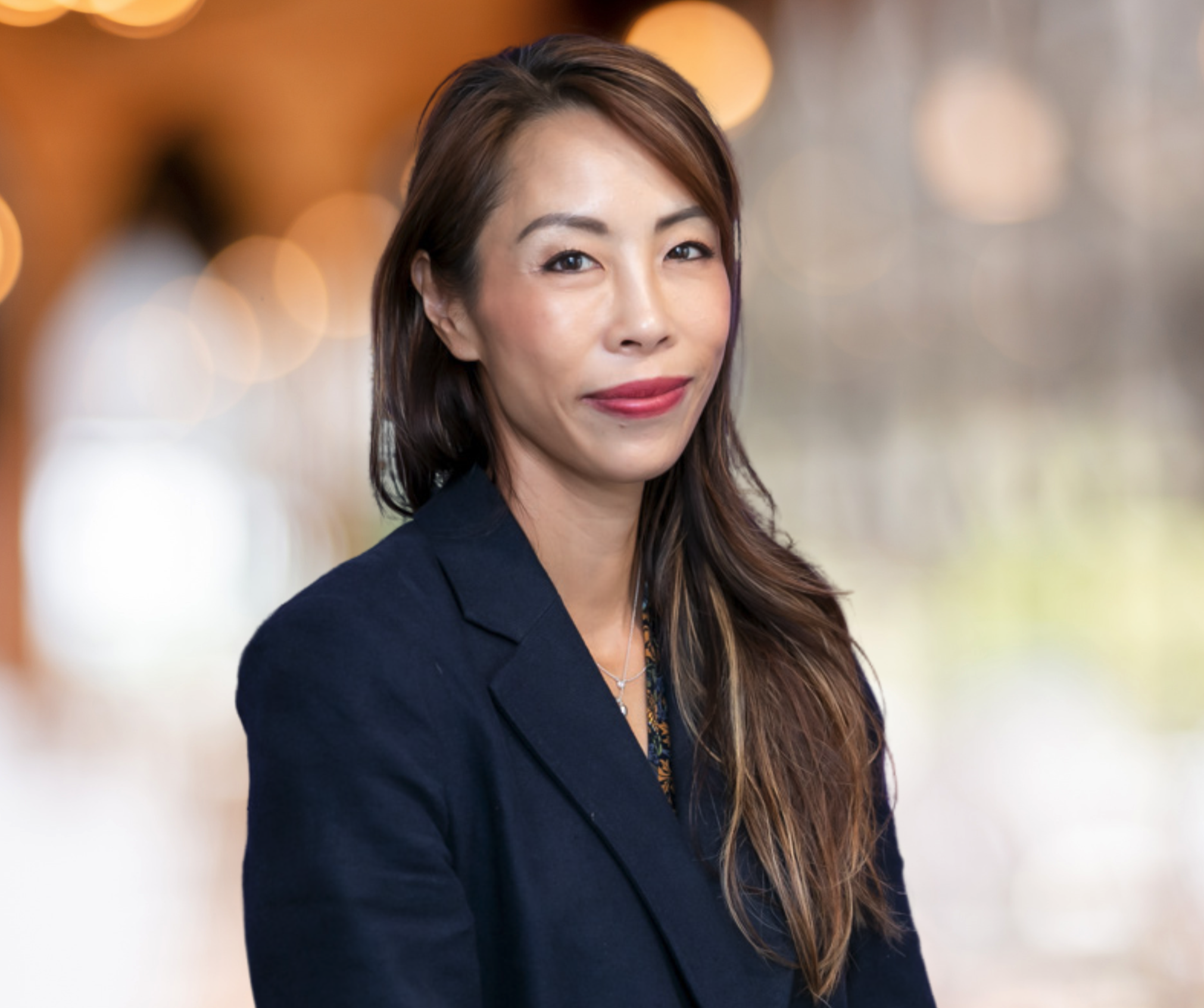 Picture of woman in a suit jacket with long hair and red lipstick