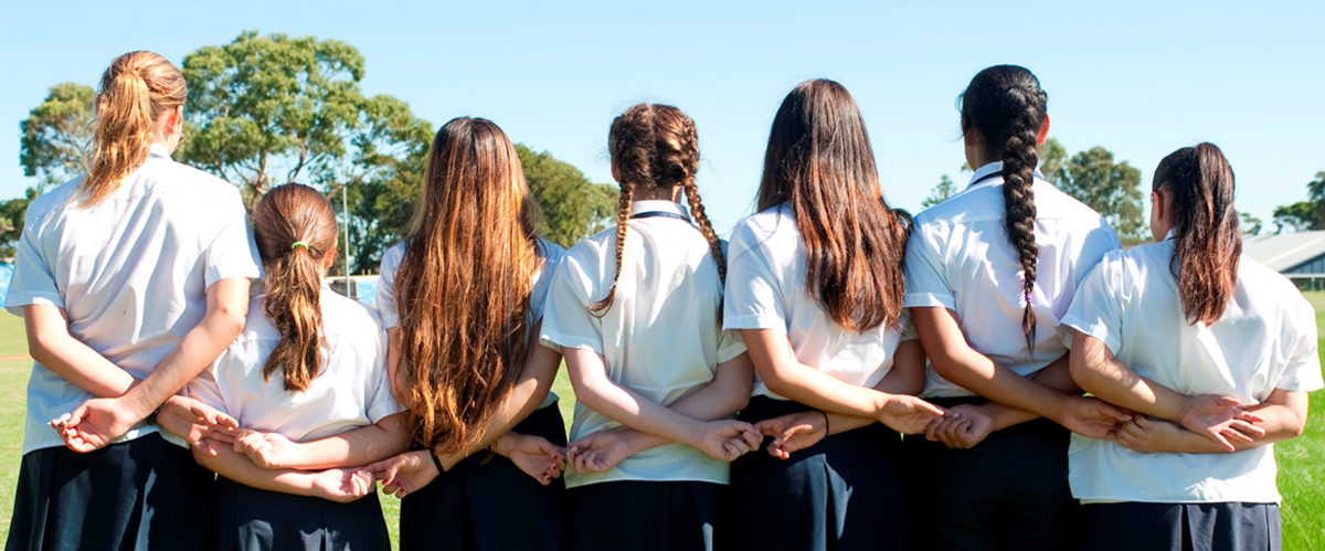 Picture of a row of school girls with their back to the camera