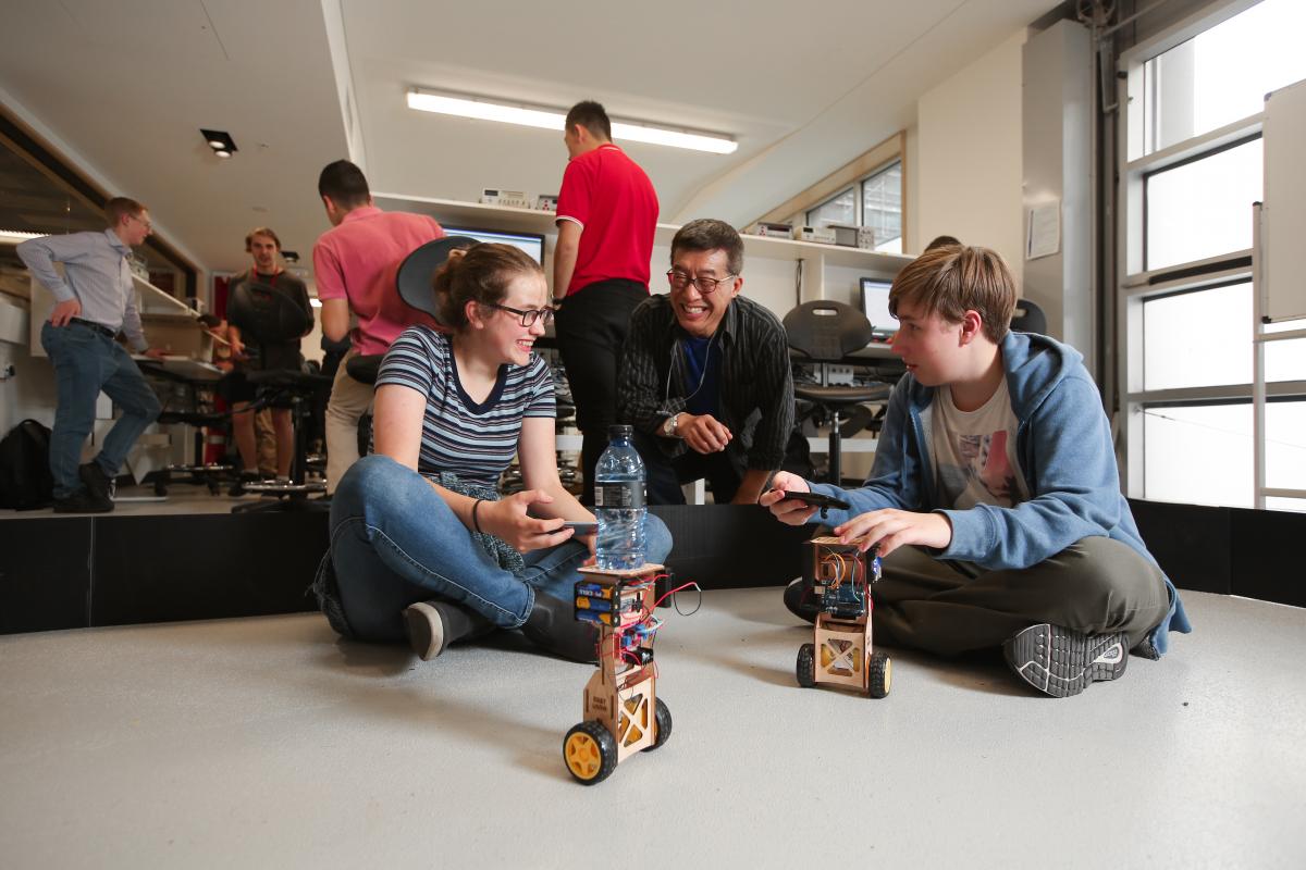 students on floor with small robots