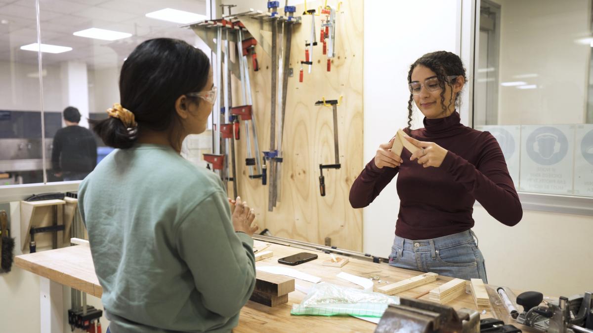 Photo of two girls making things with wood in a workshop