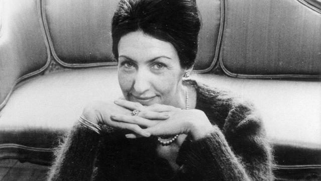 black and white photo of Shirley Hazzard sitting in front of a sofa with her hands under her chin