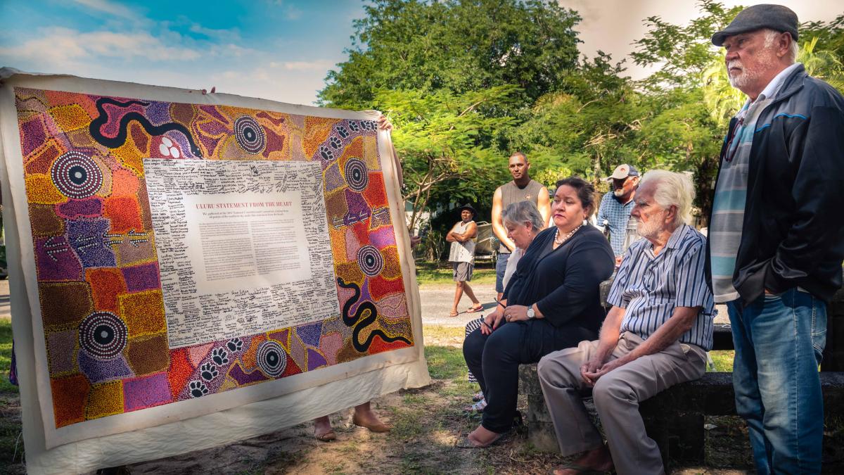 photo of th Uluru Statement framed with people sitting around it, outdoors, Cairns 2019