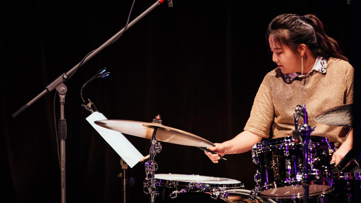 Photo of Chloe Kim at a drum kit