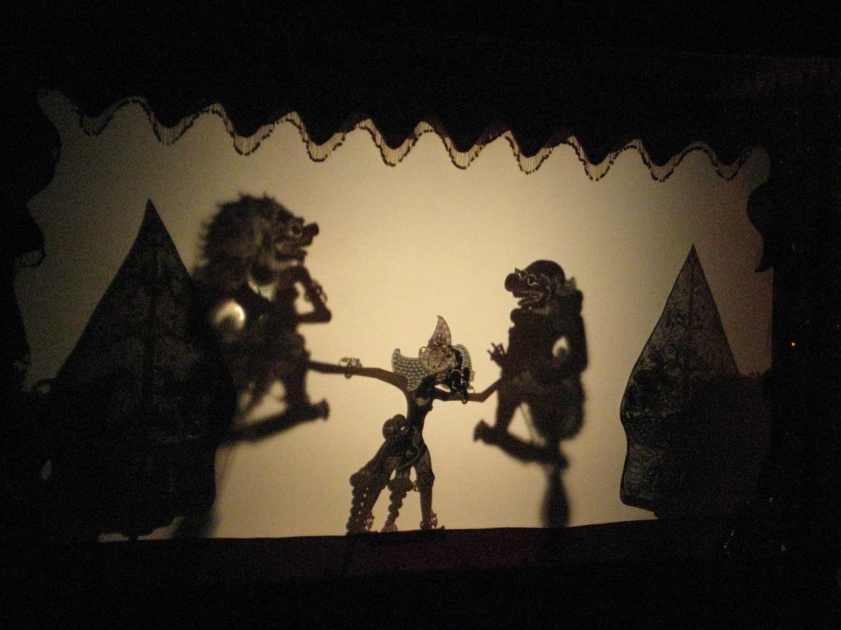 Shadow puppets against a lit wall