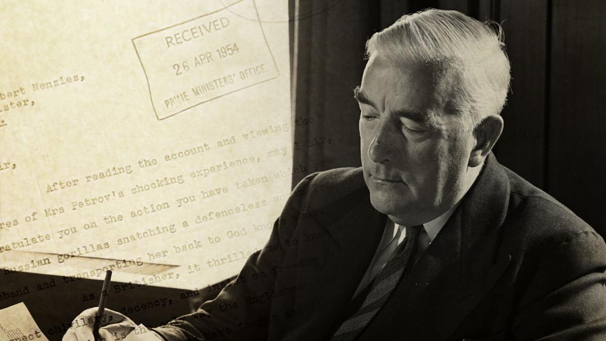photo of a man writing with a letter on the screen behind