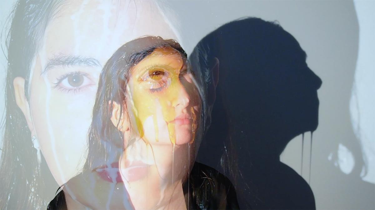 Two photos overlaid. One with a woman looking directly at you, water poured over her. The other photo is of the same woman, looking to the right, honey poured over her. 