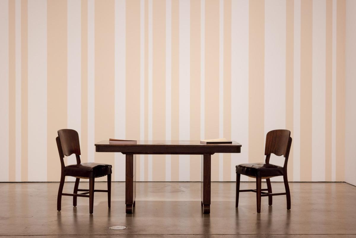 table and two chairs in front of a painted wall
