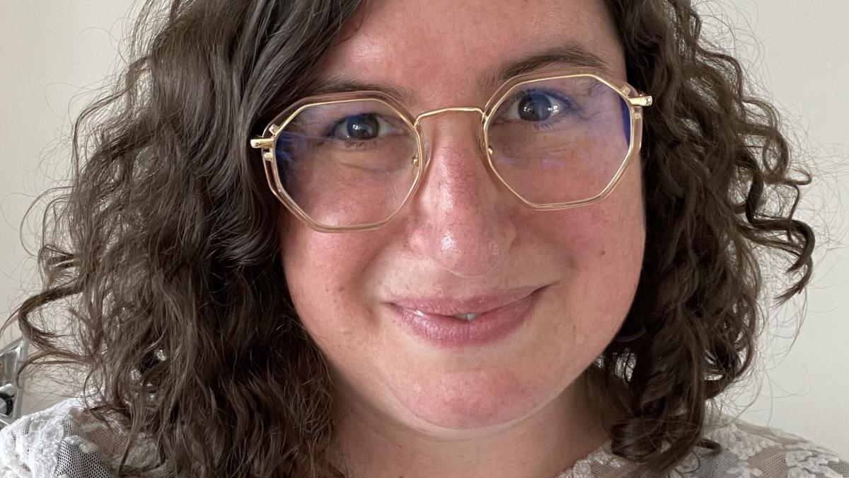 women with brown hair and glasses, smiling.