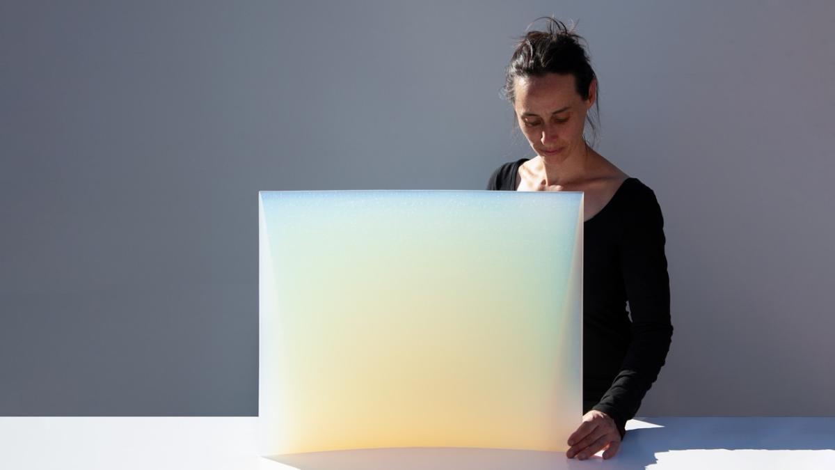 A portrait of Jessica Loughlin with her artwork.