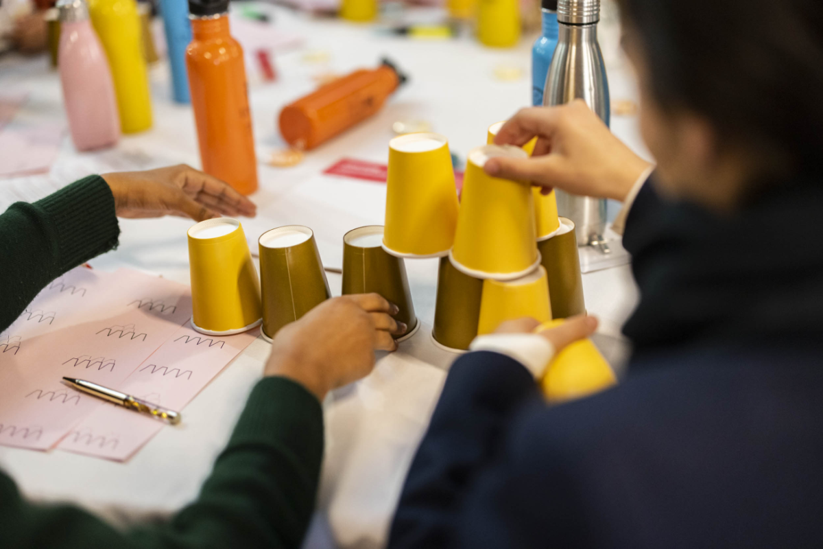 Students at a table arranging cups as part of the workshop