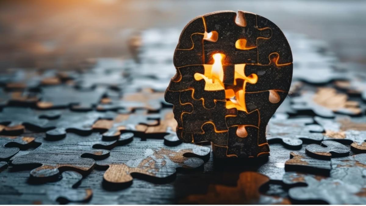 a silhouette of a human head sat atop an array of puzzle pieces