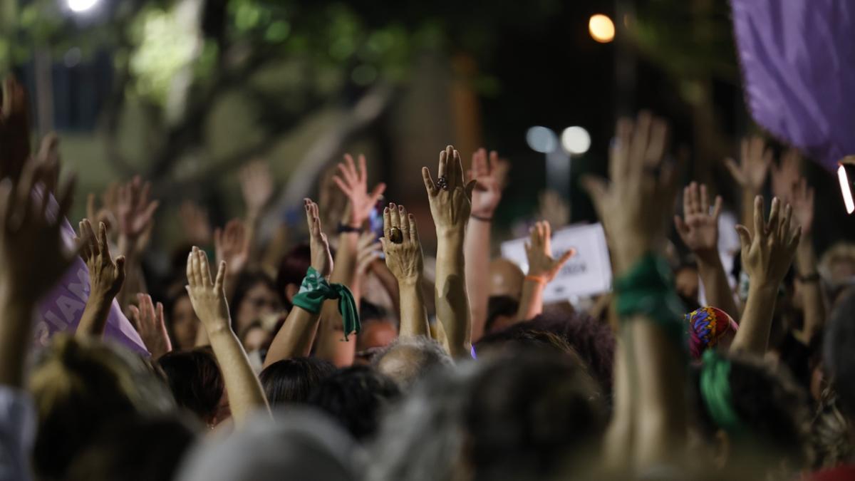a crowd gathering in protest with their hands raised