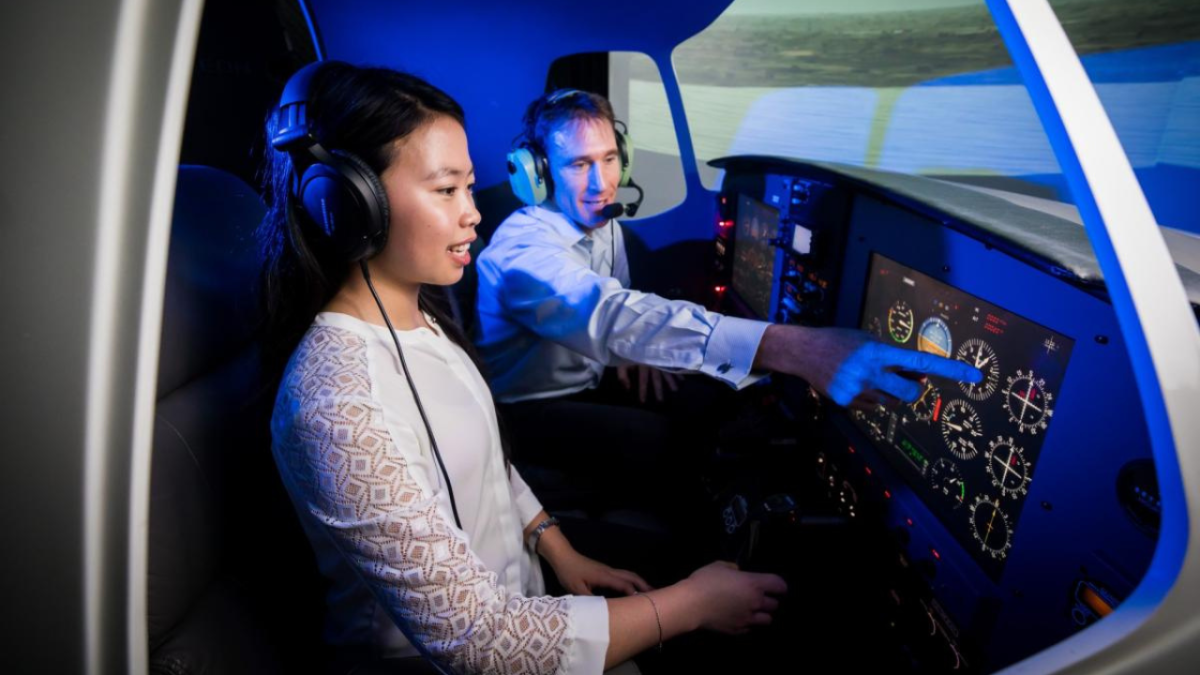 A flight instructor teaching a female student how to fly a plane