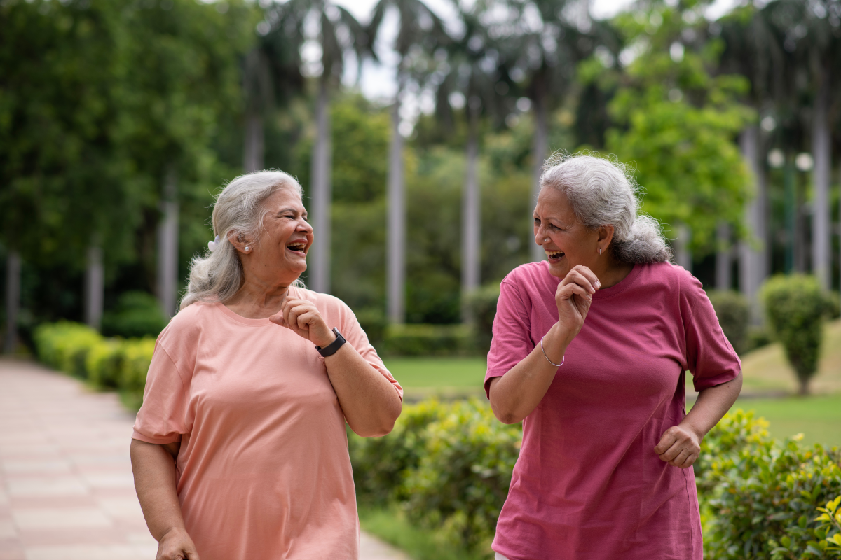 two older women walking in park and talking together
